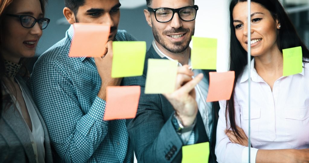 liderança unindo-se a sua equipe e alinhando ideias com post-its